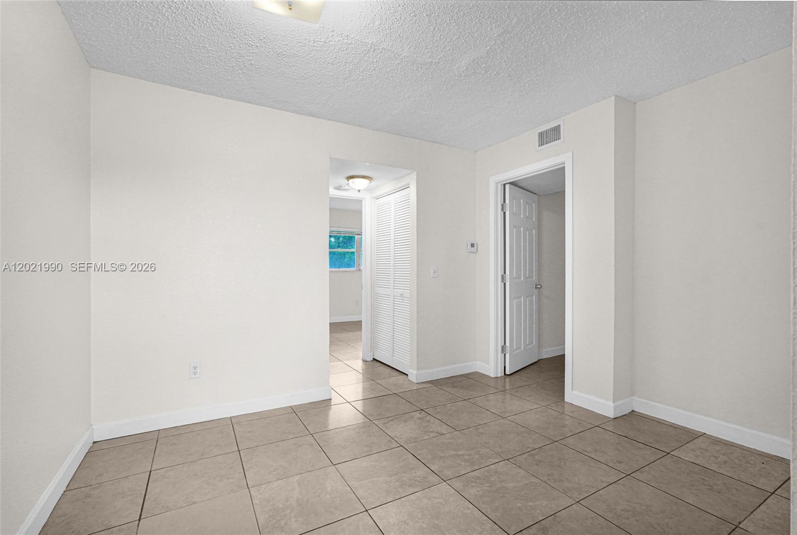 An interior room features beige tile flooring, white walls, a textured ceiling, and two doorways — 400 NW 65th Ave # 222, Margate FL 33063, MARGATE, FL