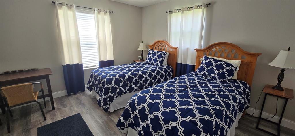 A bedroom features two twin beds with blue and white patterned bedding and wood headboards — 712 ARTESIA AVENUE, THE VILLAGES, FL