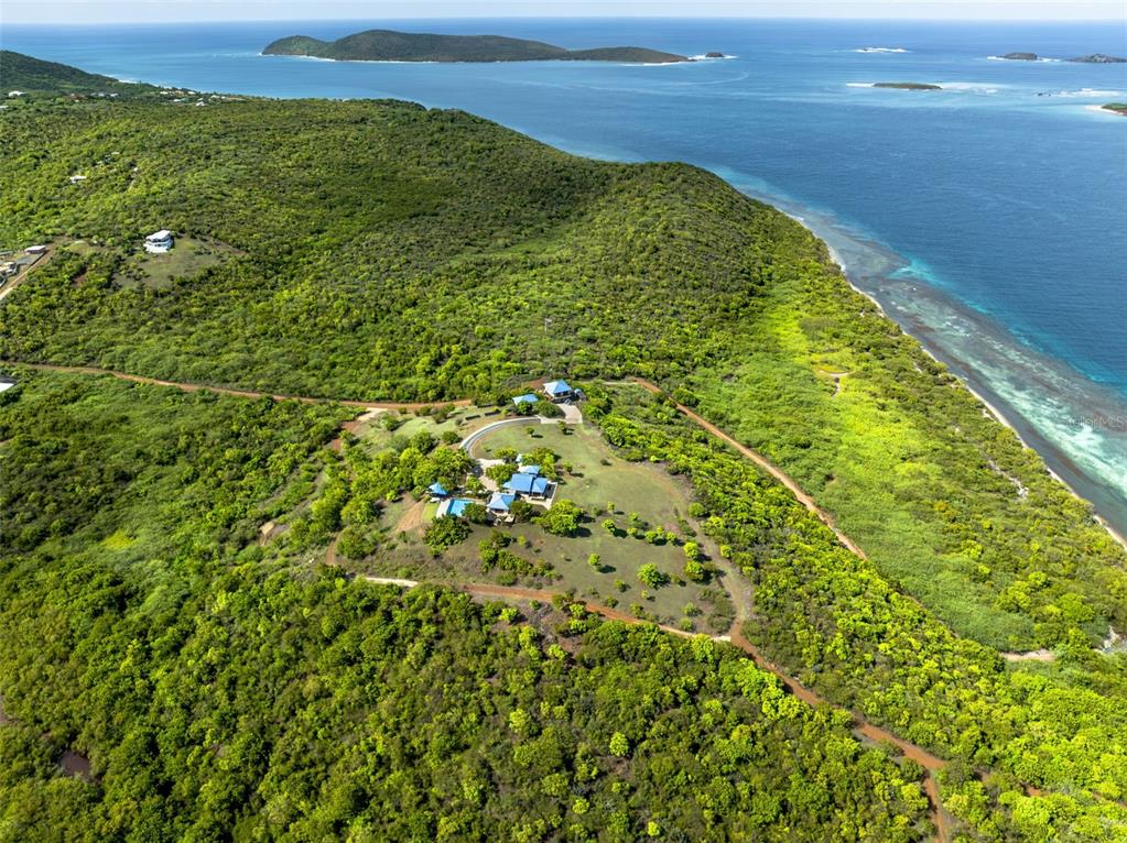 An aerial view shows a house with a pool situated on a lush, hilly coastal landscape — 37 BARRIO FRAILES, CULEBRA, PR