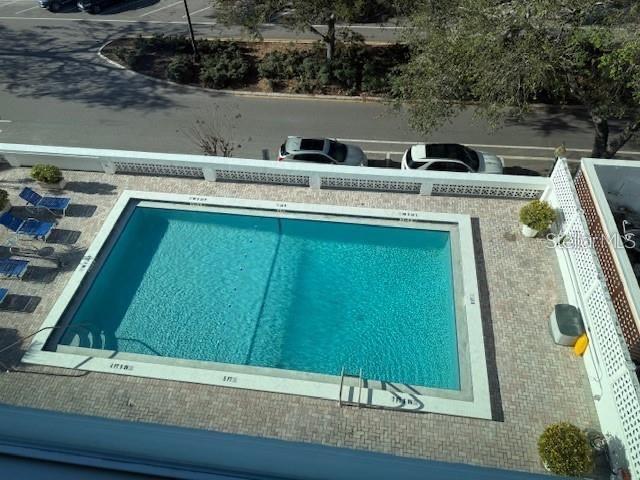 An aerial view shows a rectangular swimming pool surrounded by a paved deck and parking — 33 S GULFSTREAM AVENUE UNIT 307, SARASOTA, FL