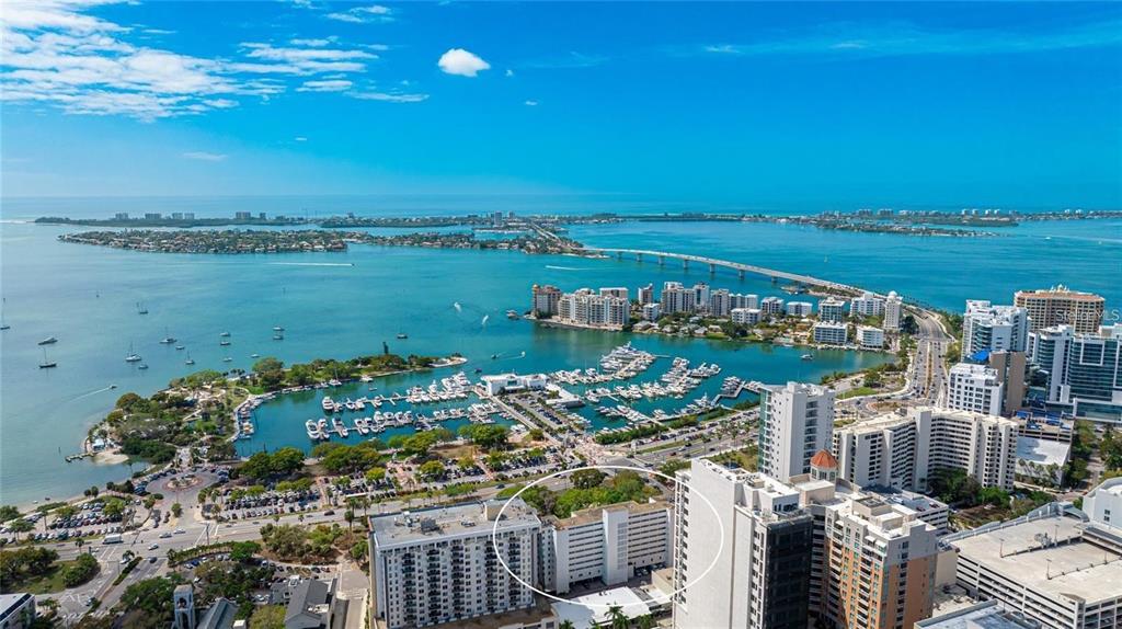 An aerial view shows a coastal city with a high-rise building circled in white — 33 S GULFSTREAM AVENUE UNIT 307, SARASOTA, FL