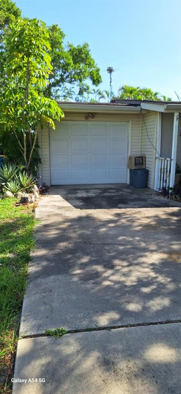 A kitchen features white cabinets, a stainless steel oven, a microwave, and terracotta tile flooring — 138 FRANCIS DRIVE NE, PORT CHARLOTTE, FL
