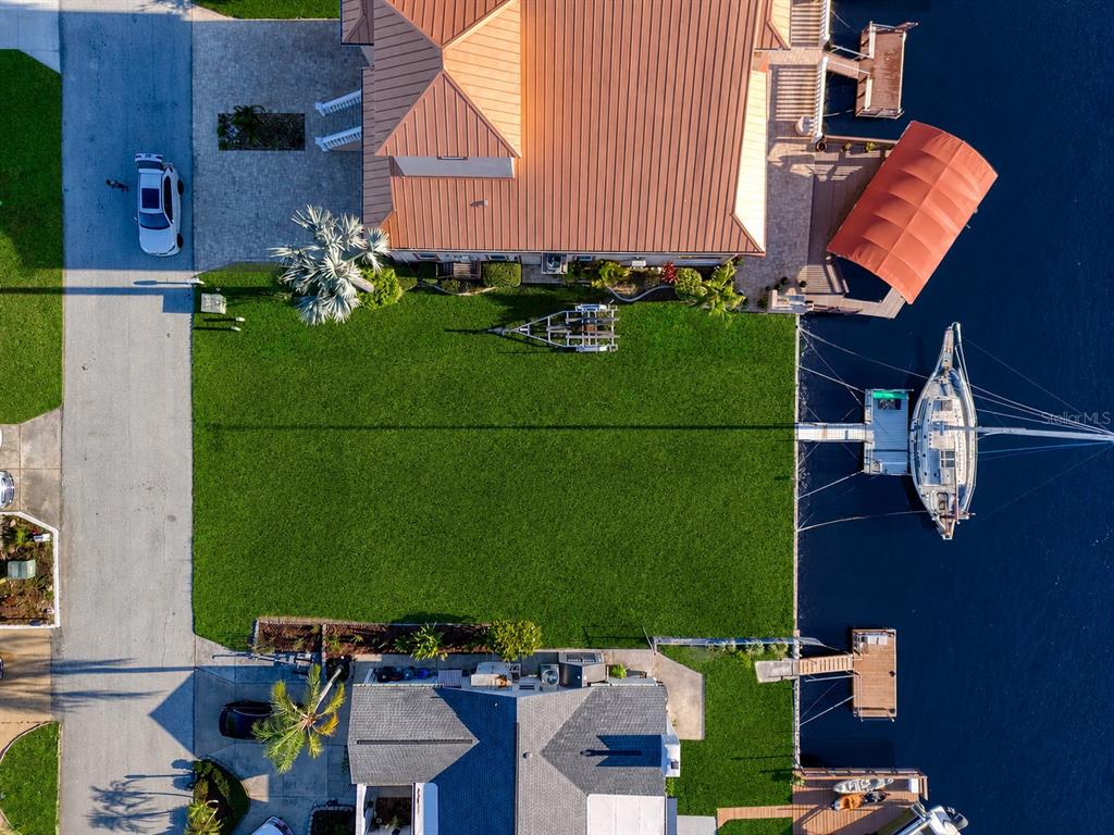 An aerial view shows two waterfront houses with boat docks and a shared grassy yard — SOUTHWIND DRIVE lot 130, HUDSON, FL