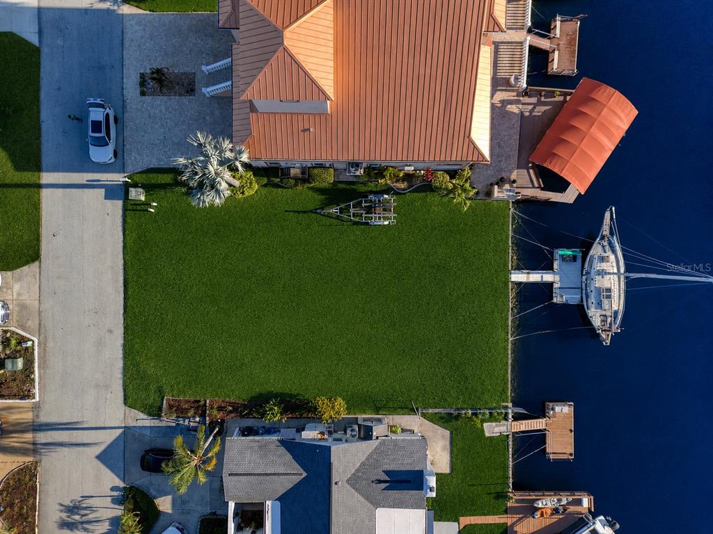 An aerial view shows two waterfront homes with a large shared lawn and boat docks — SOUTHWIND DRIVE lot 130, HUDSON, FL