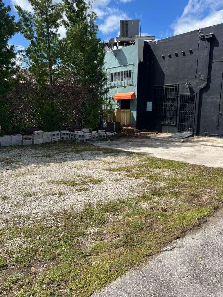 A gravel lot sits in front of a teal and black building with an orange awning — 924 71st Street, Miami Beach FL 33141, MIAMI BEACH, FL