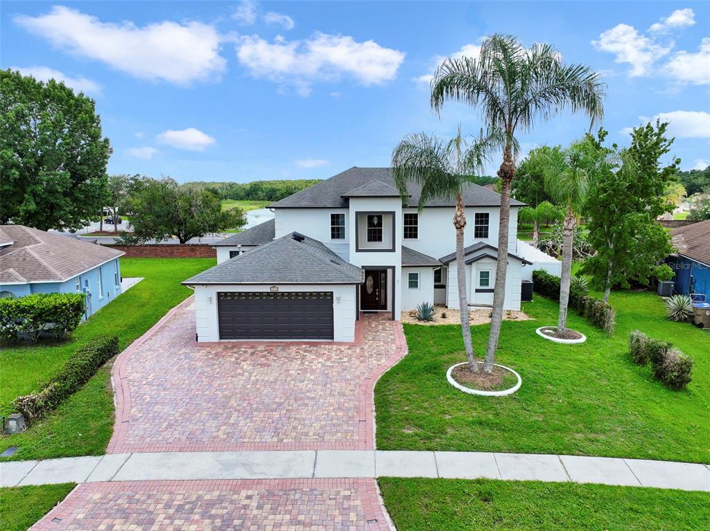 A two-story house with a brick paver driveway and a dark garage door — 2574 SAGE DRIVE, KISSIMMEE, FL