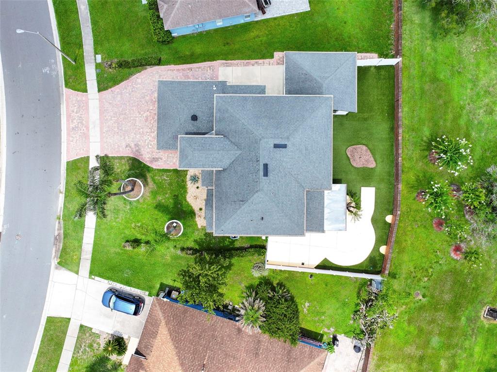 An aerial view shows a residential house with a gray roof, driveway, and backyard lawn — 2574 SAGE DRIVE, KISSIMMEE, FL