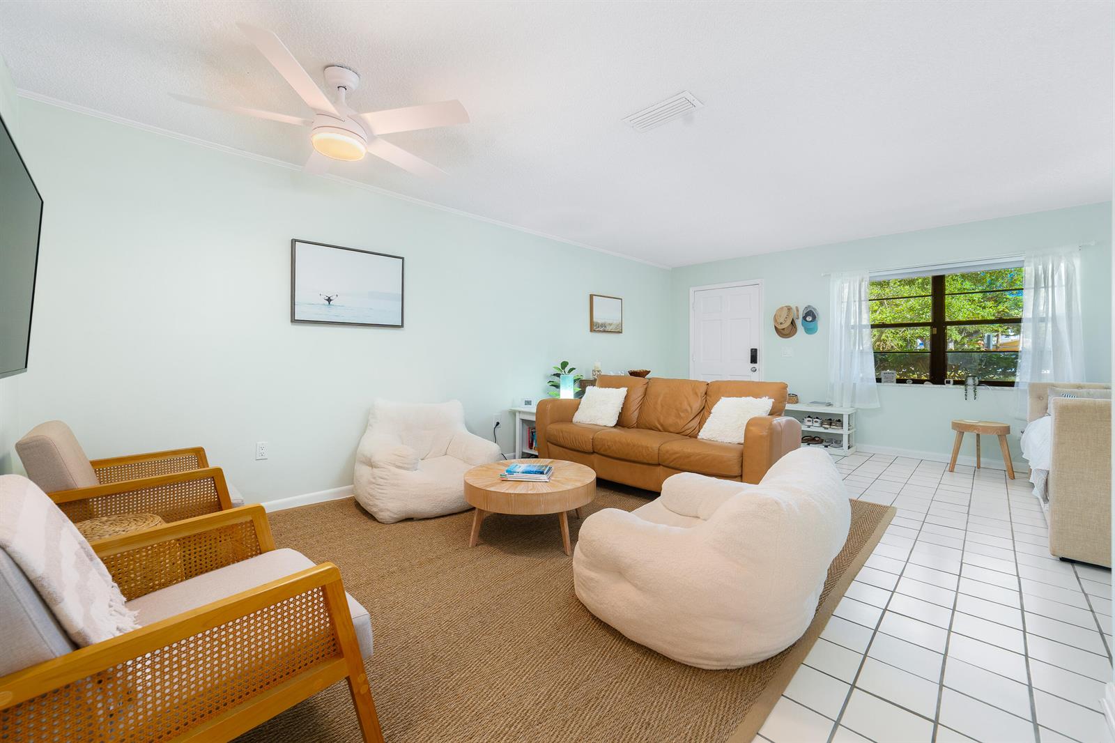 A living room features a tan leather sofa, two white armchairs, and two wooden chairs — 839 Camelia Lane # 8, Vero Beach FL 32963, VERO BEACH, FL