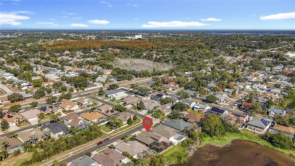 An aerial view shows a suburban neighborhood with a red pin marking a specific house — 4961 W BREEZE CIRCLE, PALM HARBOR, FL