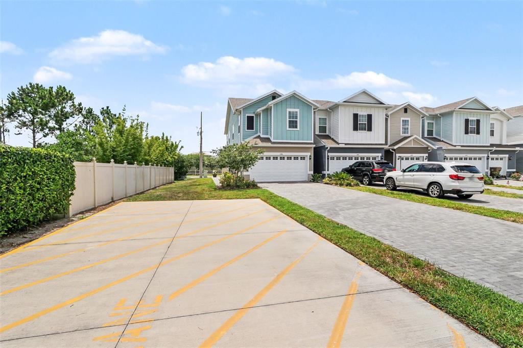 The exterior of a two-story teal and gray townhouse with a small concrete patio — 1180 WYCLIFFE WAY, ST CLOUD, FL