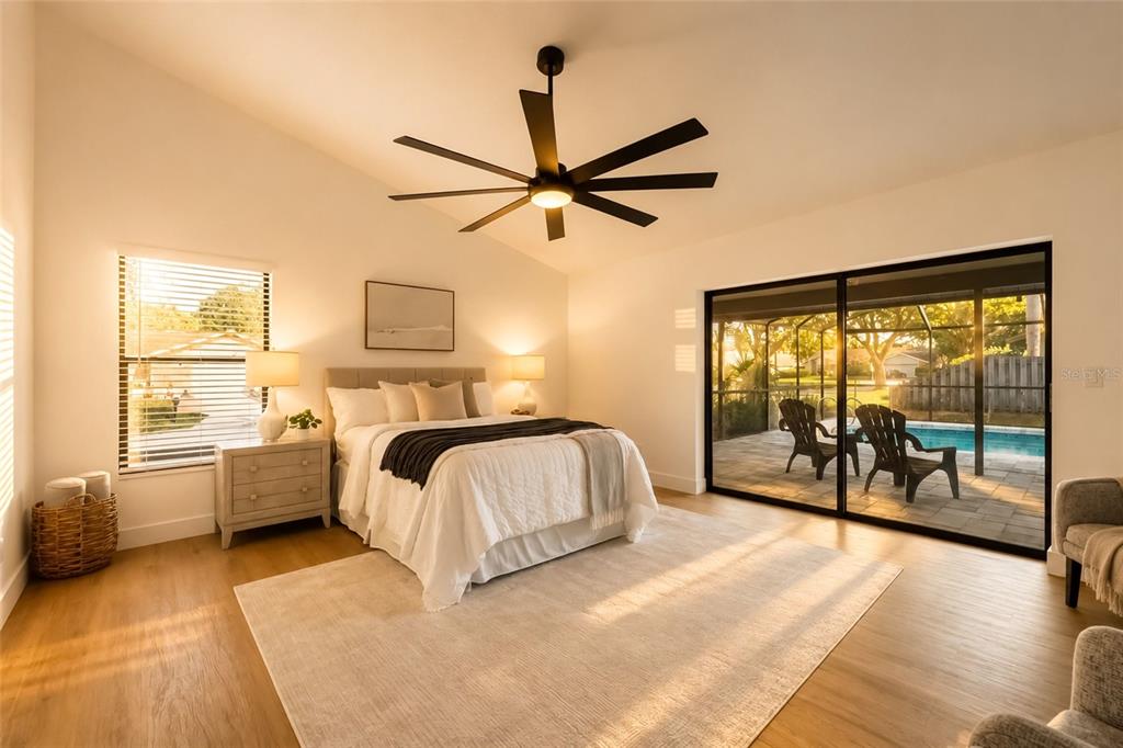 A bedroom with a ceiling fan, bed, and sliding glass doors opening to a pool patio — 2700 SEDGEFIELD COURT E, CLEARWATER, FL