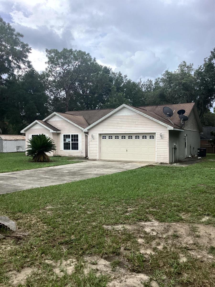A single-story house with light pink siding, a two-car garage, and a concrete driveway — 11880 SE 195th Place, FL 34431, FL