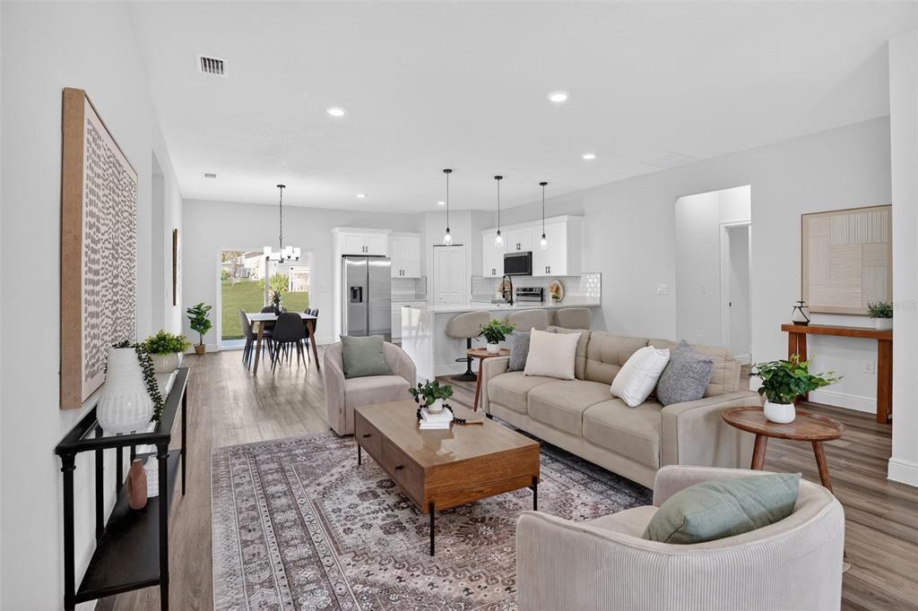 An open-concept living room and kitchen feature light wood flooring and neutral modern furniture — 9129 N ANTON WAY, CITRUS SPRINGS, FL