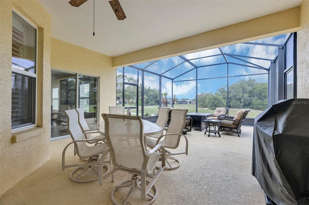 A covered patio features outdoor furniture, a ceiling fan, and a screened-in enclosure — 4334 BENT CREEK LANE, LEESBURG, FL