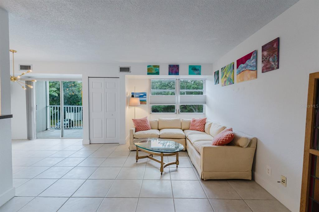 A living room features a beige sectional sofa, a glass coffee table, and tiled floors — 3315 58TH AVENUE S UNIT 222, ST PETERSBURG, FL