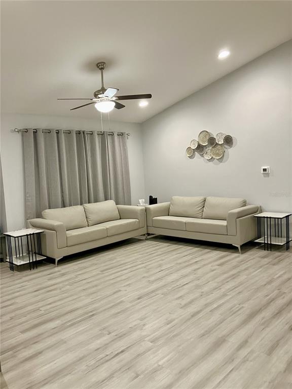 A living room features two light-colored sofas, side tables, and a ceiling fan — 5415 SW 153RD PLACE ROAD, OCALA, FL