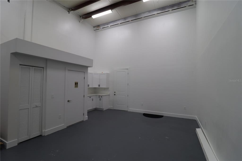 An interior view of a commercial space with high ceilings, white walls, and gray flooring — 1225 TAMIAMI TRAIL UNIT A8, PORT CHARLOTTE, FL