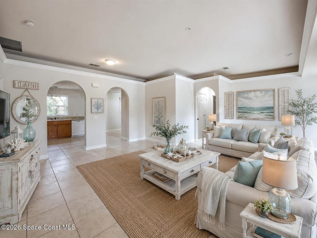A living room with tile floors, a white coffee table, and beige sofas — 1582 PENTAX AVENUE, TITUSVILLE, FL