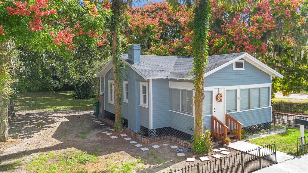 A blue, single-story house with a front porch and lattice skirting sits on a lot — 135 S ARLINGTON AVENUE, DELAND, FL