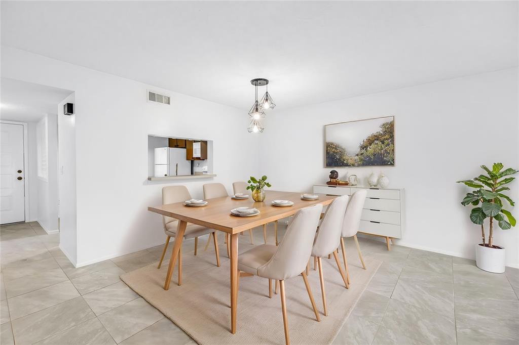 A dining room with a wooden table, six chairs, a pendant light, and tile flooring — 3600 MAGNOLIA RIDGE CIRCLE UNIT 1224, PALM HARBOR, FL