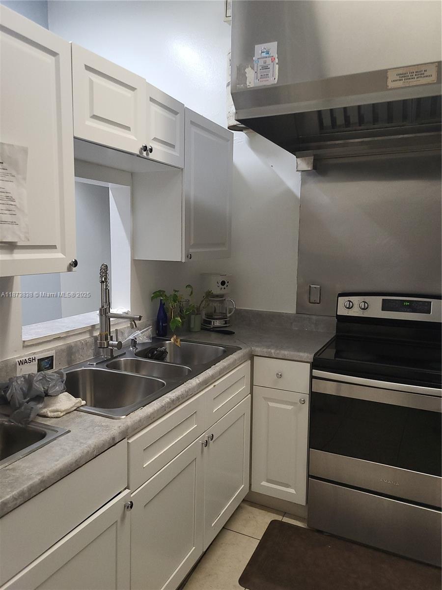 A kitchen features white cabinets, a double-basin stainless steel sink, and a stainless steel range — 3621 NW 90th Ter, Sunrise FL 33351, SUNRISE, FL