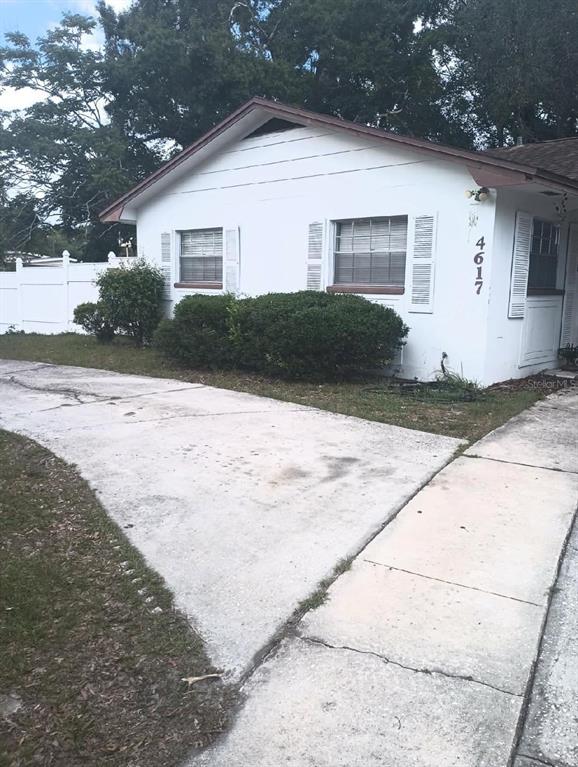 A white single-story house with a paved driveway, palm trees, and a mailbox in front — 4617 SNOOK DRIVE, TAMPA, FL