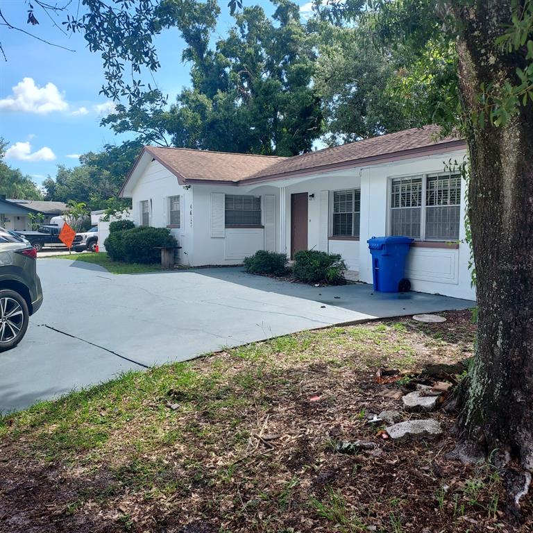 A white single-story house with a painted driveway and a blue trash bin outside — 4617 SNOOK DRIVE, TAMPA, FL