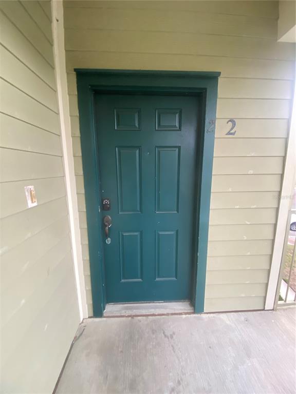 A teal front door with a digital lock is set into light green horizontal siding — 3721 S LAKE ORLANDO PARKWAY UNIT 2, ORLANDO, FL