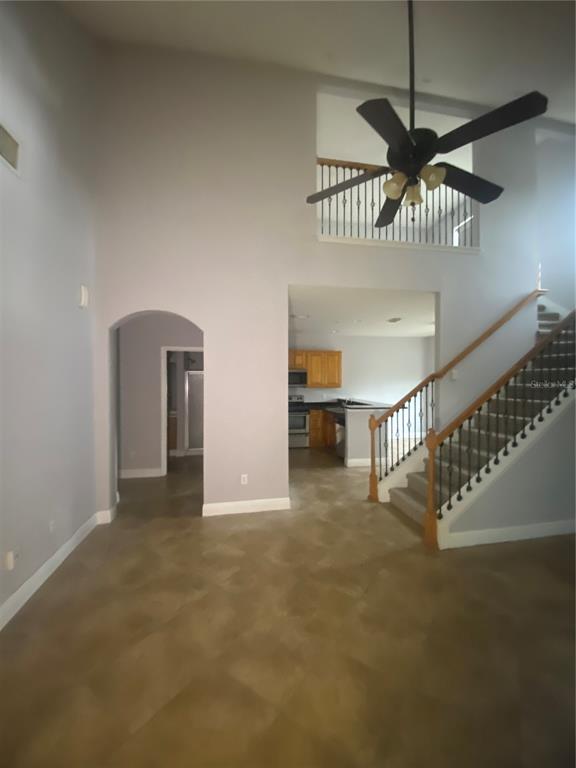 A living area with tile flooring, a staircase, and a view into the kitchen — 3721 S LAKE ORLANDO PARKWAY UNIT 2, ORLANDO, FL