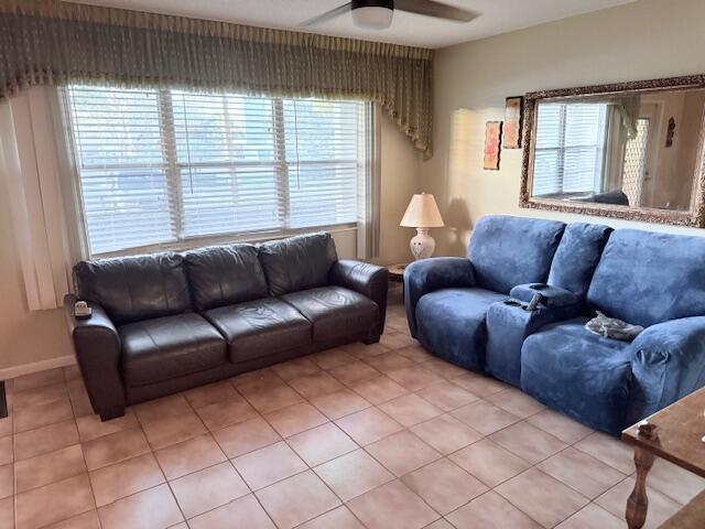 A living room features a dark leather sofa, a blue reclining loveseat, and tiled floors — 1027 Berkshire B, Deerfield Beach FL 33442, DEERFIELD BEACH, FL