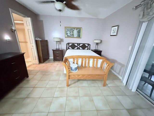 A bedroom features a bed with a wooden bench, tile flooring, and a ceiling fan — 1027 Berkshire B, Deerfield Beach FL 33442, DEERFIELD BEACH, FL