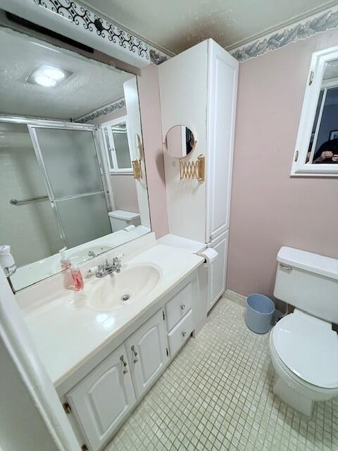 A bathroom features a white vanity with a sink, a tall cabinet, and a toilet — 1027 Berkshire B, Deerfield Beach FL 33442, DEERFIELD BEACH, FL