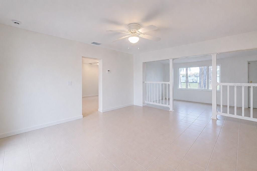 An interior view of a room with white walls, tiled floors, and a ceiling fan — 426 ELLA AVENUE, INVERNESS, FL