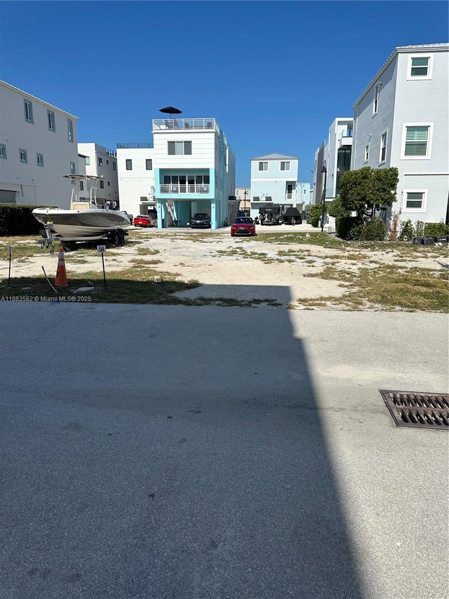 A vacant dirt lot sits between several multi-story residential buildings and parked vehicles — 94825 Overseas Hwy, Key Largo FL 33037, KEY LARGO, FL