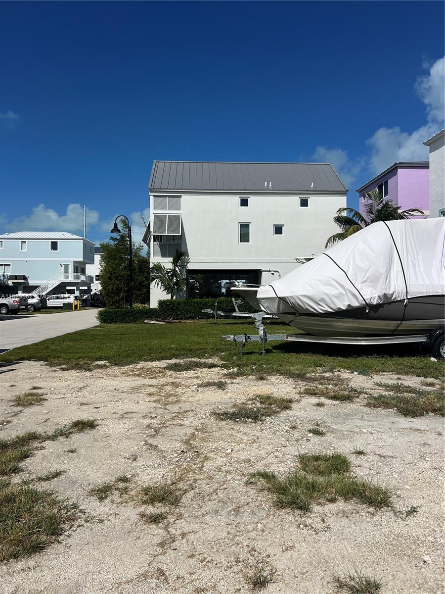 A white house with a metal roof stands behind a boat on a trailer — 94825 Overseas Hwy, Key Largo FL 33037, KEY LARGO, FL