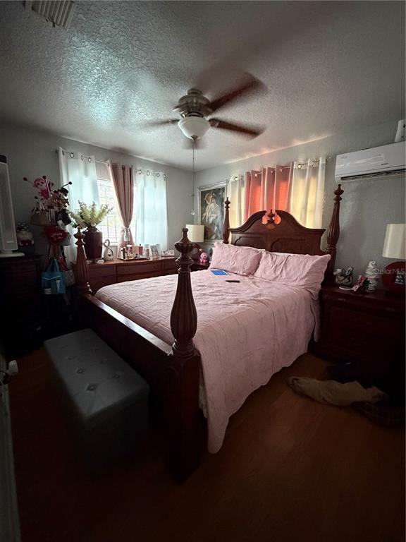 A bedroom features a wooden four-poster bed, a ceiling fan, and a wall-mounted air conditioner — 4162 KINGSBRIDGE DRIVE, ORLANDO, FL