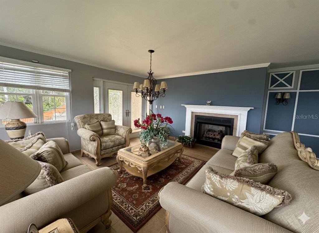 A living room features a fireplace, a chandelier, two sofas, and an armchair — Bo Beatriz Las Piñas FINCA MI RECREO  LOT 28, CAGUAS, PR