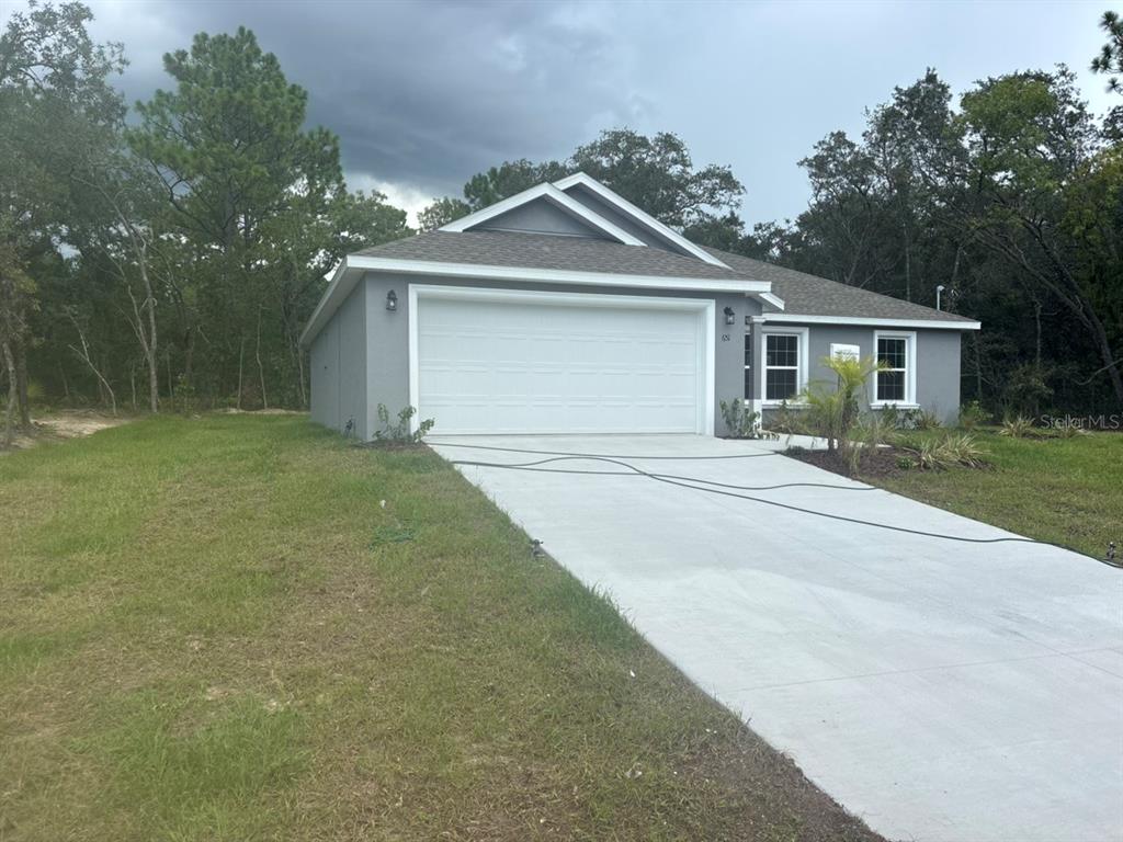 A gray single-story house with a white garage door and a concrete driveway — 651 W BANCROFT DRIVE, DUNNELLON, FL