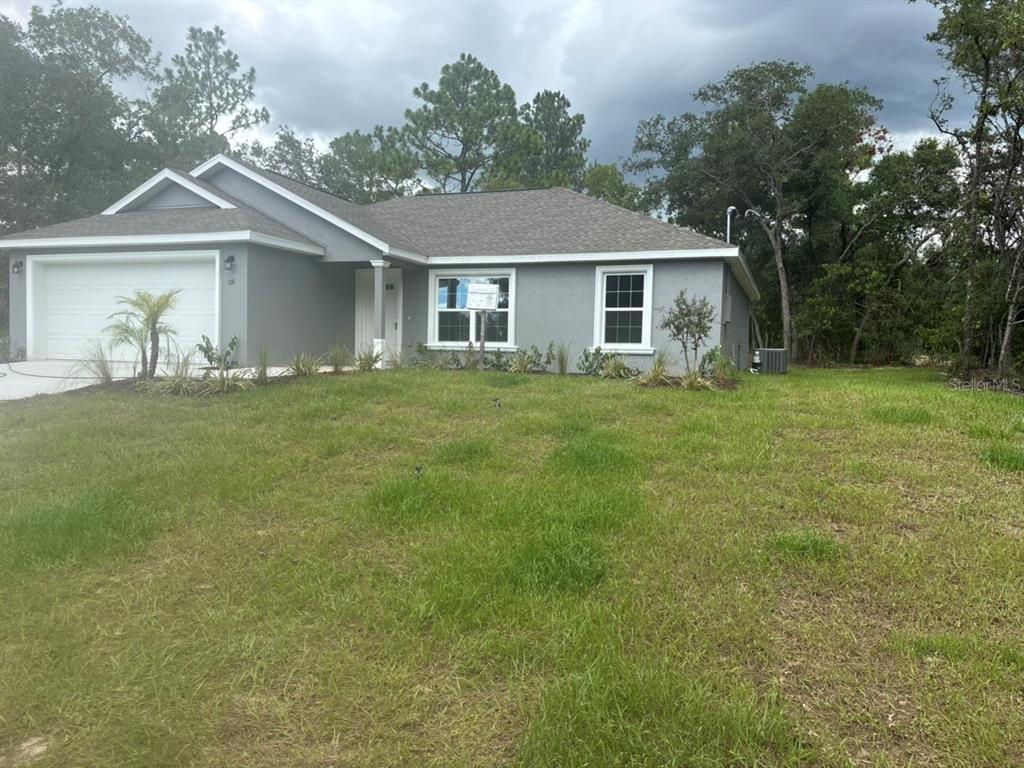 A single-story gray house with a two-car garage sits on a grassy lot — 651 W BANCROFT DRIVE, DUNNELLON, FL