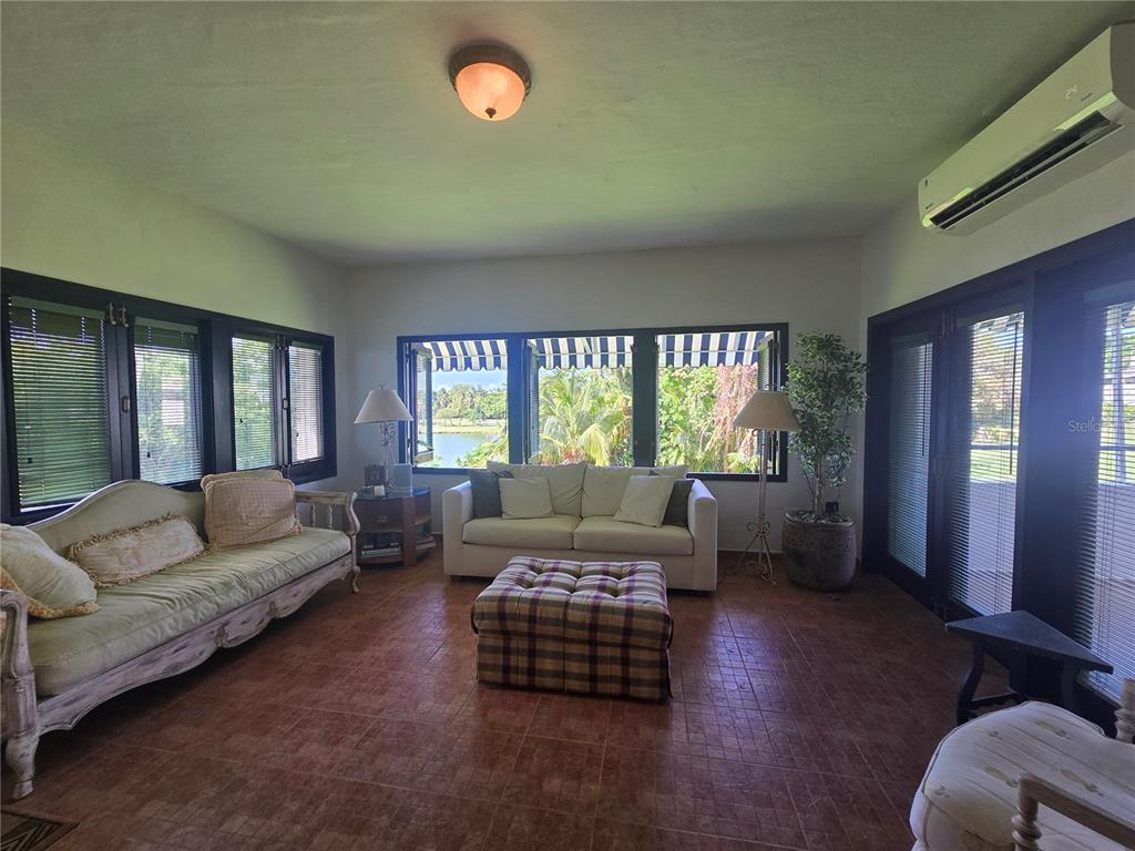 A sunroom features tile floors, a white sofa, a vintage-style couch, and large windows — Cluster 2, 40-B CLUSTER 2, RIO MAR, RIO GRANDE, PR