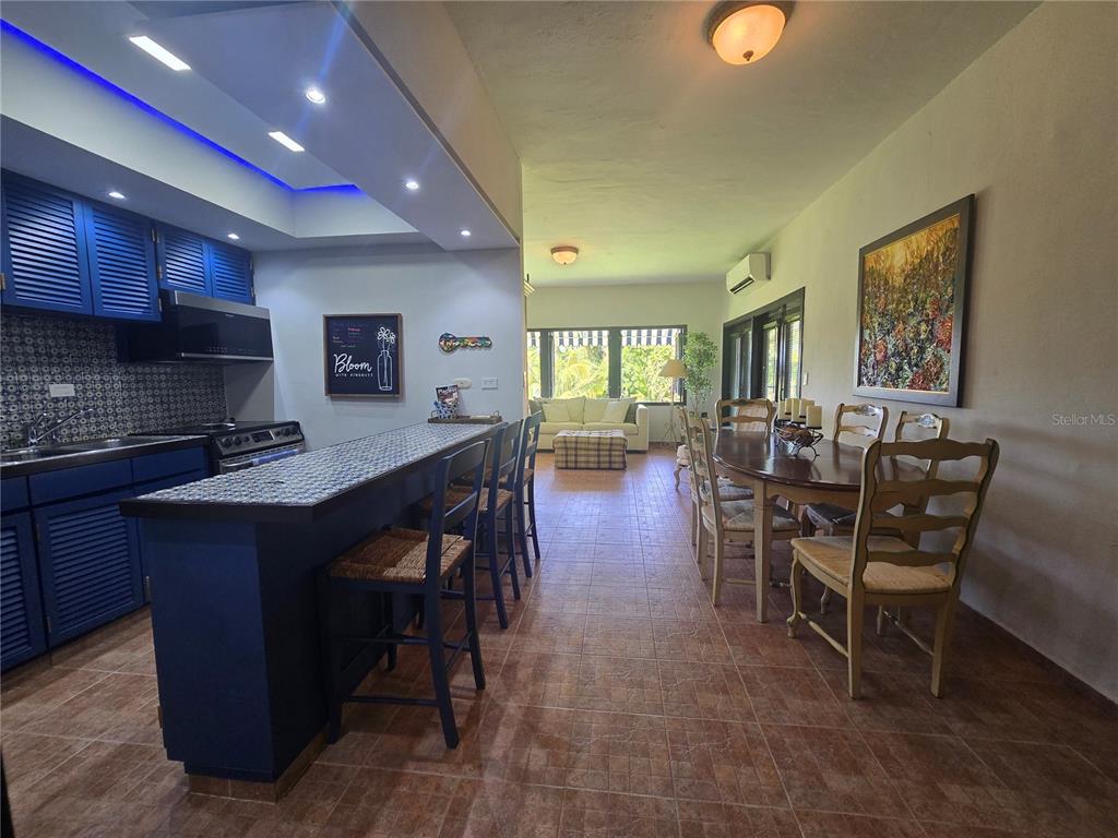 A kitchen with blue cabinets and a breakfast bar opens into a dining area — Cluster 2, 40-B CLUSTER 2, RIO MAR, RIO GRANDE, PR