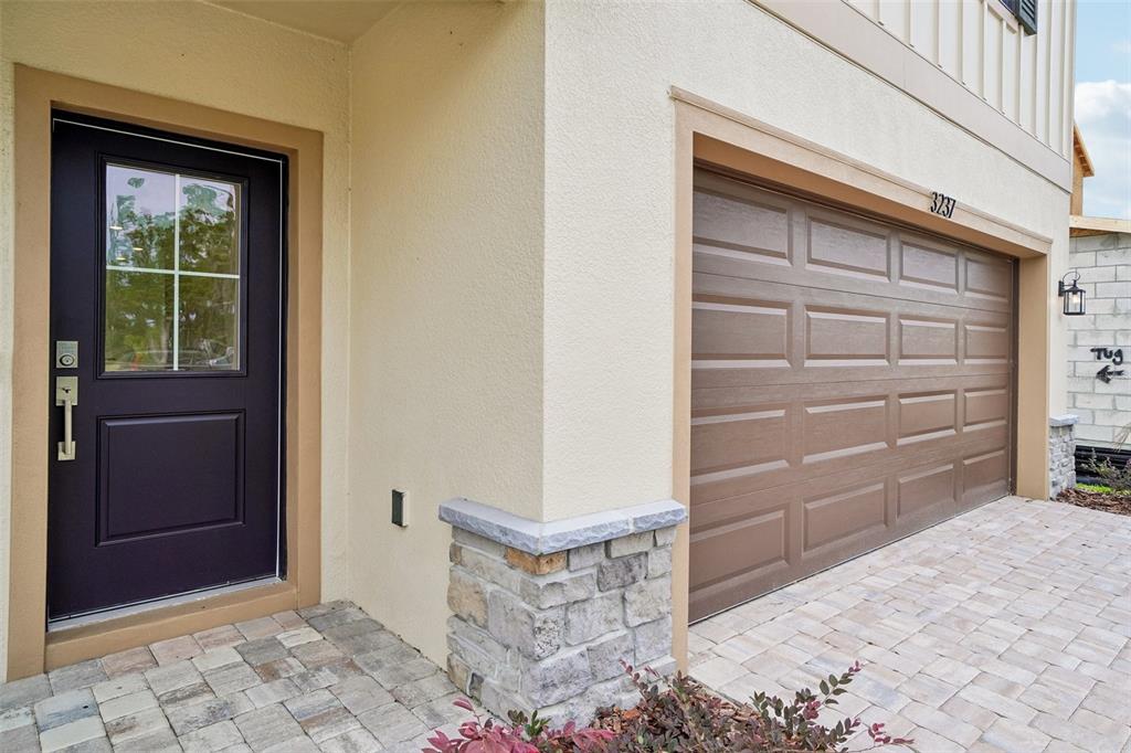A dark front door and a brown garage door are set against a beige exterior wall — 3237 CUP DRIVE, LAKELAND, FL