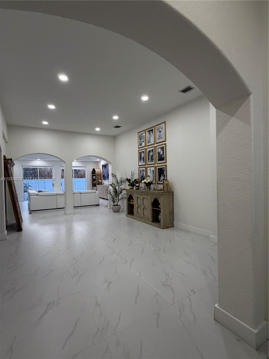 A bright, open-concept living area features white marble-look tile floors and a wooden console table — 3744 SW 156th Ct, Miami FL 33185, MIAMI, FL