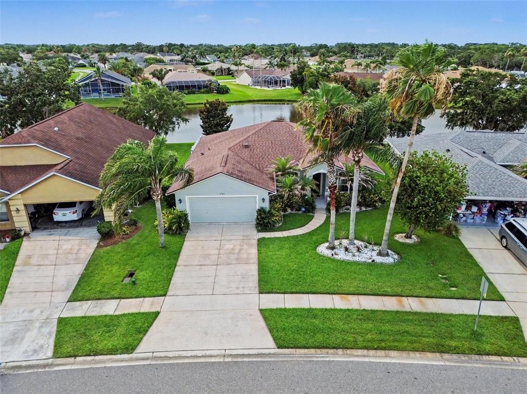 A single-story house with a two-car garage, palm trees, and a landscaped front yard — 1754 TRIBUTORY LN, PORT ORANGE, FL