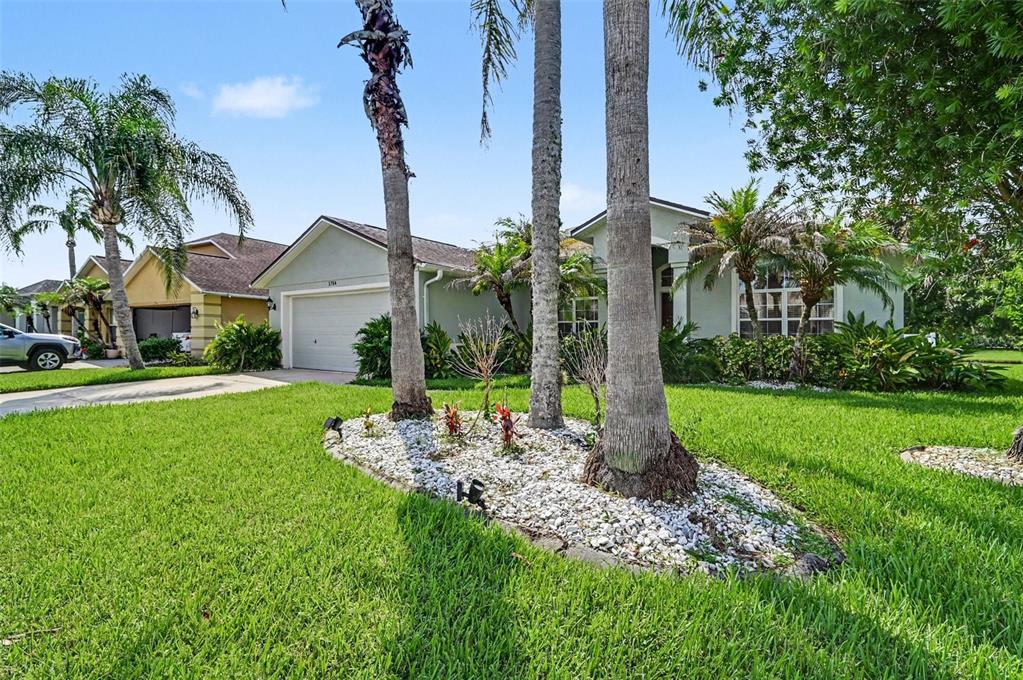A single-story house with a two-car garage and palm trees in the front yard — 1754 TRIBUTORY LN, PORT ORANGE, FL