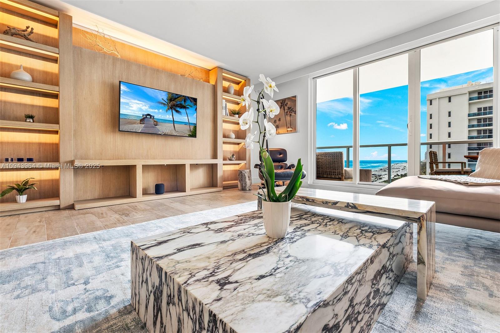 A living room features a marble coffee table, built-in wooden shelving, and a balcony view — 102 24th St # 1120, Miami Beach FL 33139, MIAMI BEACH, FL