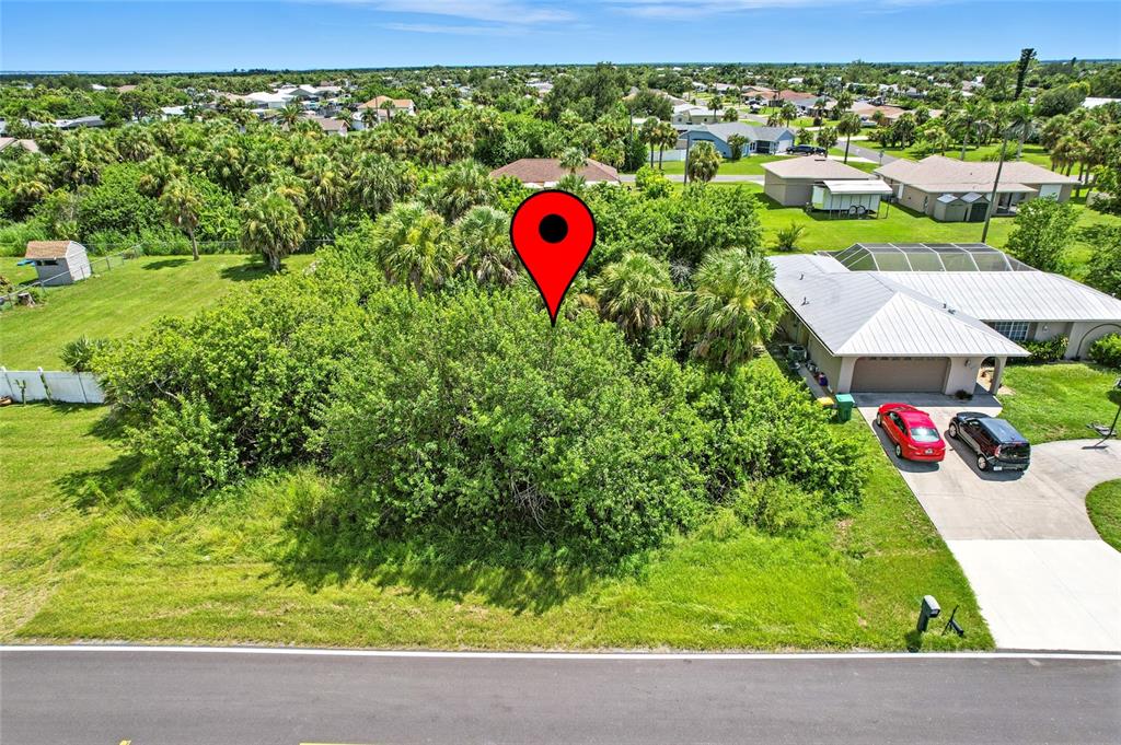 An aerial view shows a vacant, tree-covered lot next to a house with a driveway — 18645 LAKE WORTH BOULEVARD, PORT CHARLOTTE, FL
