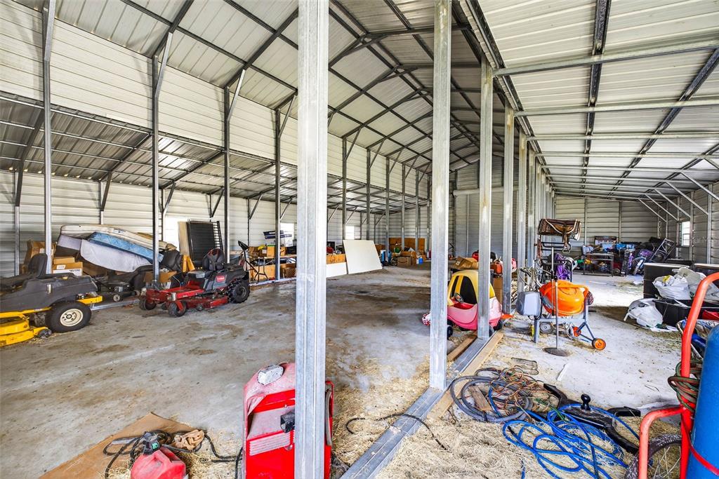 A large, open-sided metal storage building with a concrete floor and various stored equipment — 4361 COOPER ROAD, PLANT CITY, FL