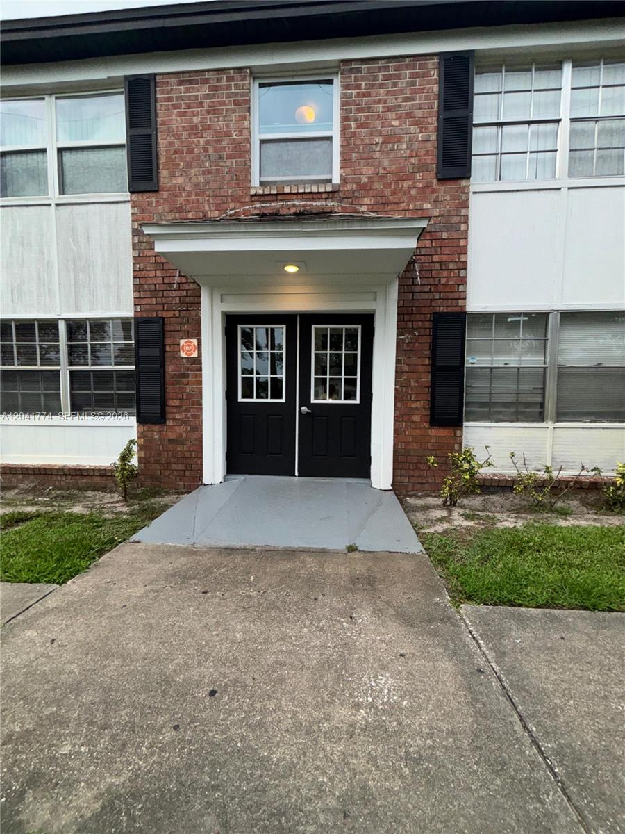 A brick building exterior features a central double door entrance with a small porch — 5325 Curry Ford Rd # A104, Orlando FL 32812, ORLANDO, FL