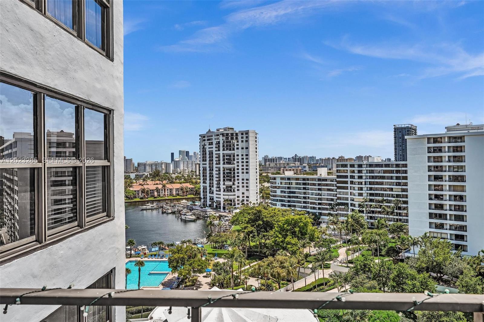 A balcony view overlooks a marina, a swimming pool, lush landscaping, and several high-rise buildings — 2500 Parkview Dr # 1514, Hallandale Beach FL 33009, HALLANDALE BEACH, FL